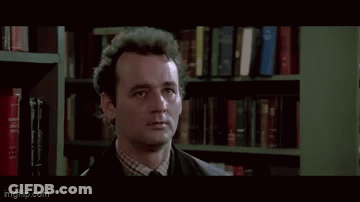Man By Bookshelf So What Do We Do GIF