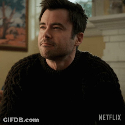 Man By Fireplace In Black Sweater Netflix Logo GIF