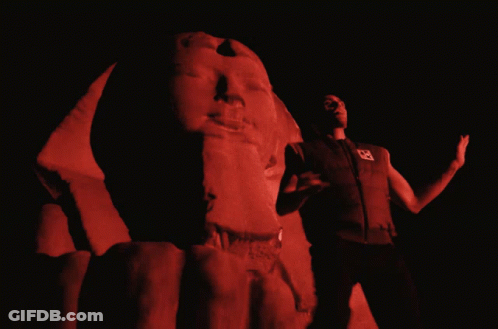 Man By Red-Lit Statue GIF