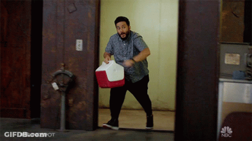 Man Carrying Red And White Cooler With NBC Logo GIF