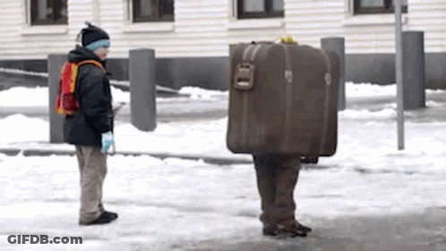 Man Carrying Suitcase On Back In Snow GIF