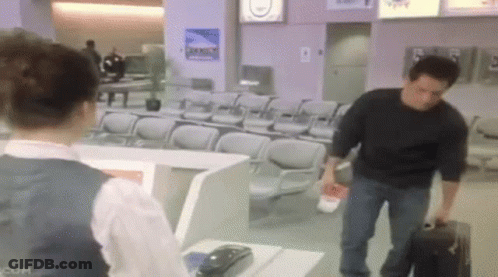Man Carrying Suitcase Talking To Woman GIF