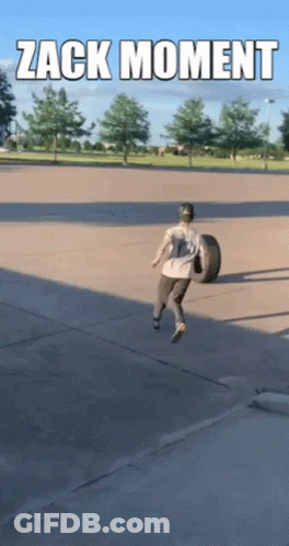 Man Carrying Tire In Parking Lot GIF
