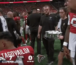 Man Carrying Tray Of Cans On Field GIF