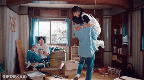 Man Carrying Woman On Back In Messy Room GIF