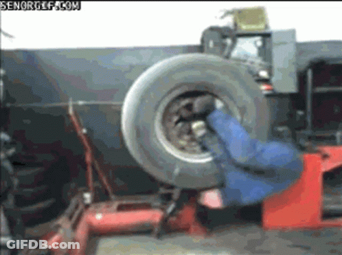 Man Changing Tire On Machine GIF