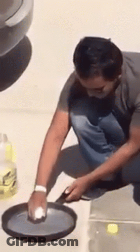 Man Cleaning Pan With Sponge GIF