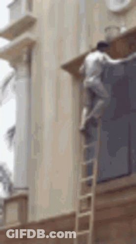 Man Climbing Ladder To Paint Building GIF