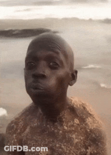 Man Covered In Sand Looking Seriously At Camera GIF