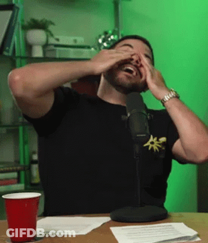Man Covering Eyes While Sitting At Microphone GIF