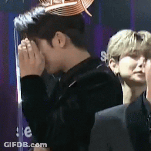 Man Covering Face In Front Of Crowd GIF