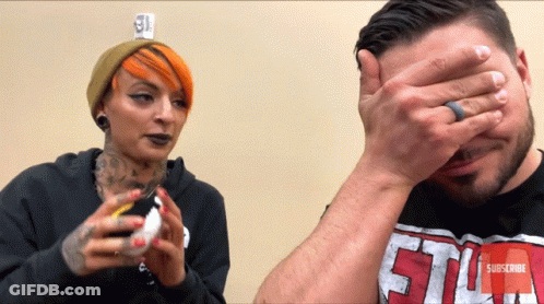 Man Covering Face Next To Red Haired Woman GIF