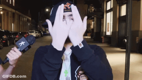 Man Covering Face With Hands Holding Microphone GIF