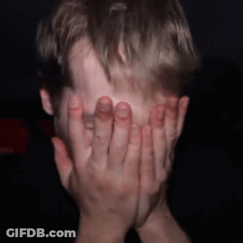 Man Covering Face With Hands In Dark Room GIF