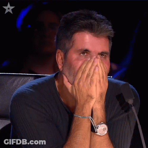 Man Covering Face With Hands In Front Of Microphone GIF