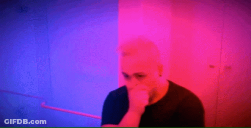 Man Covering Mouth In Front Of Pink And Blue Background GIF