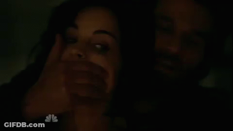 Man Covering Woman's Mouth In The Dark GIF
