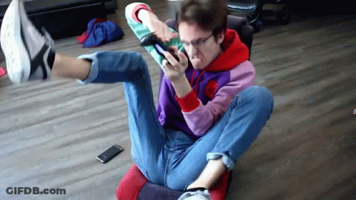 Man Crossed Legs Looking At Phone GIF