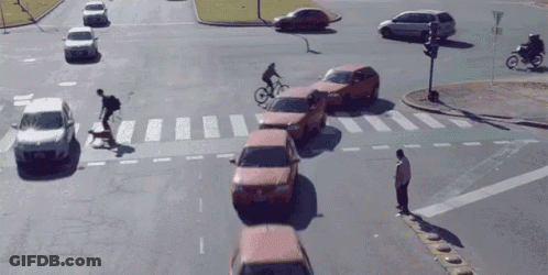 Man Crossing Street As Cyclist Rides By GIF