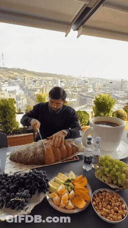 Man Cutting Loaf Of Bread With Knife GIF