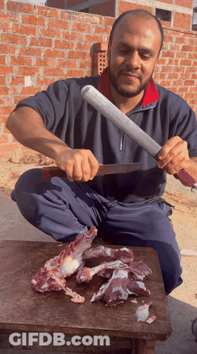 Man Cutting Meat With Large Knife GIF