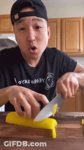 Man Cutting Yellow Item With Knife GIF