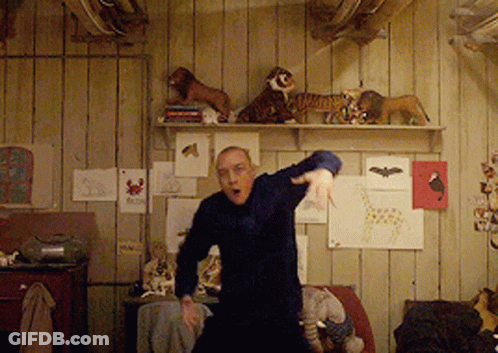 Man Dancing Among Stuffed Animals On Wall GIF