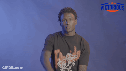 Man Dancing In Front Of Clemson Logo Brick Wall GIF