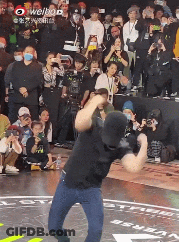 Man Dancing In Front Of Crowd With Weibo Logo GIF