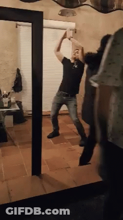 Man Dancing In Front Of Mirror In Living Room GIF