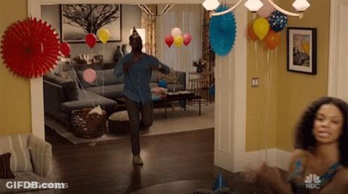 Man Dancing In Living Room With Balloons And Paper Fans GIF