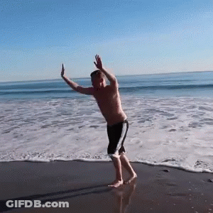 Man Dancing On Beach Arms Outstretched GIF