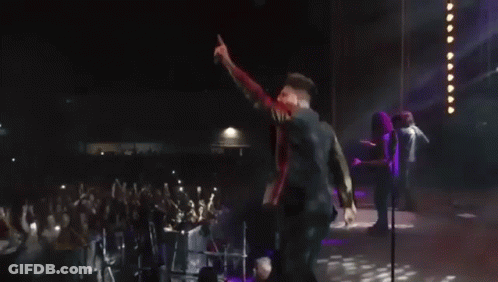 Man Dancing On Stage In Front Of Neon A GIF