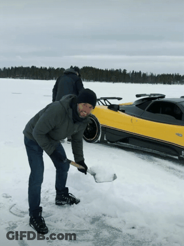 Man Digging In Snow Near Yellow Car GIF