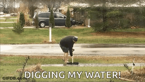 Man Digging Water With Shovel While Wearing Shorts GIF