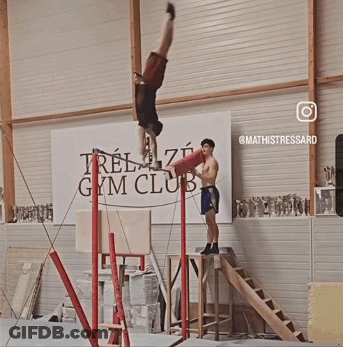 Man Doing Handstand In Front Of Gym Banner GIF