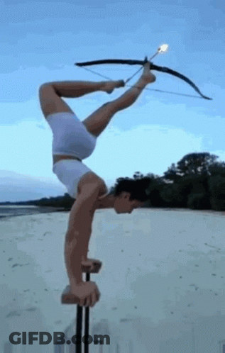 Man Doing Handstand With Bow And Arrow On Pole GIF