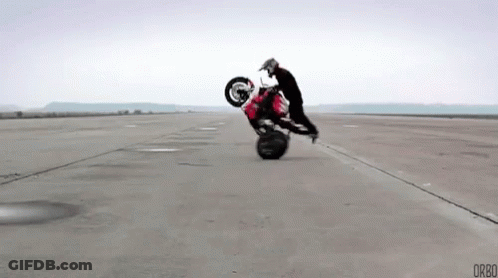 Man Doing Motorcycle Trick On Empty Road GIF