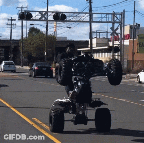 Man Doing Trick On ATV On Street GIF
