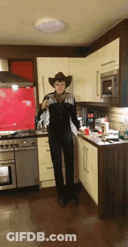 Man Dressed As Cowboy In Kitchen GIF