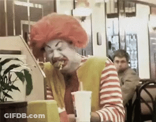 Man Dressed As McDonald's Clown Eating Hamburger GIF
