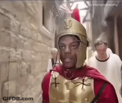 Man Dressed As Roman Soldier Walking Down Alley GIF