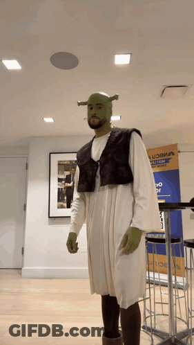 Man Dressed As Shrek In Front Of UCB Sign GIF