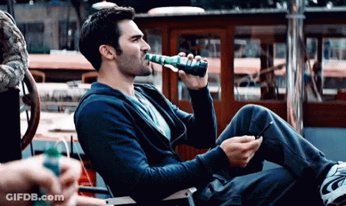 Man Drinking Bottle Holding Cell Phone GIF
