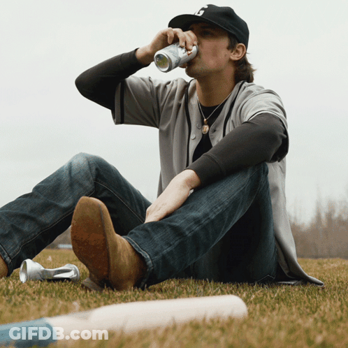 Man Drinking Can With B On Grass GIF