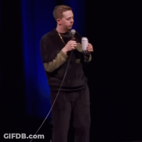 Man Drinking From Can On Stage Holding Microphone GIF