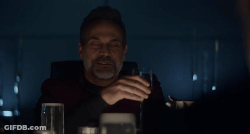 Man Drinking From Glass In Front Of 70 Sign GIF