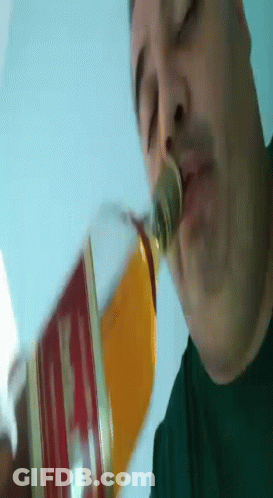 Man Drinking From Glass With Coin In Nose GIF