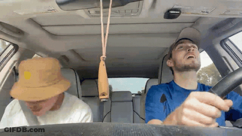 Man Driving Car With Whistle Hanging From Roof GIF