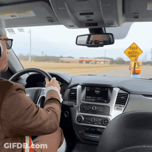 Man Driving Past Yellow Sign Cale Duty Ahead GIF